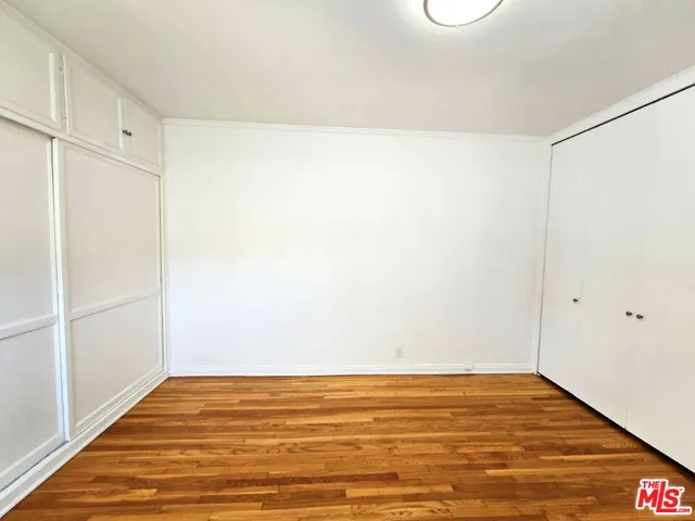 a view of a room with wooden floor and window