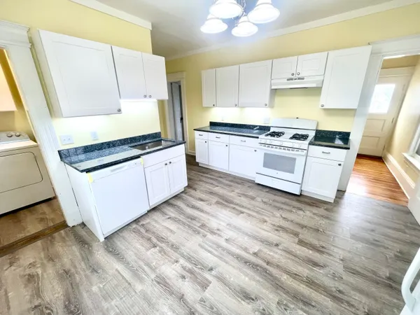 a kitchen with granite countertop white cabinets and white appliances