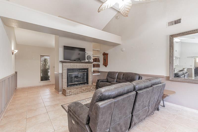 6549 North Cornelia Avenue Fresno, CA 93722 - Photo 12 of 30 a living room with furniture a fireplace and a flat screen tv