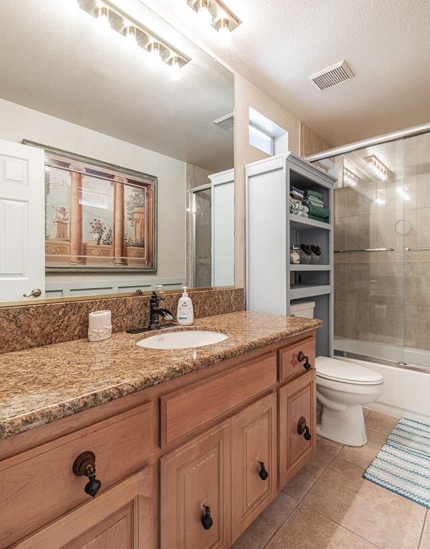 6549 North Cornelia Avenue Fresno, CA 93722 - Photo 21 of 30 a bathroom with a granite countertop toilet sink and mirror