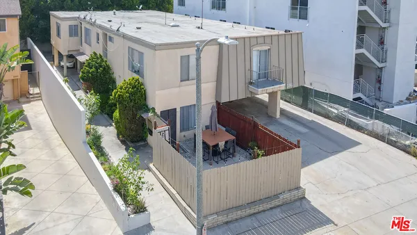 a roof deck with couches and potted plants