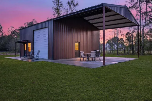a view of a house with backyard and sitting area