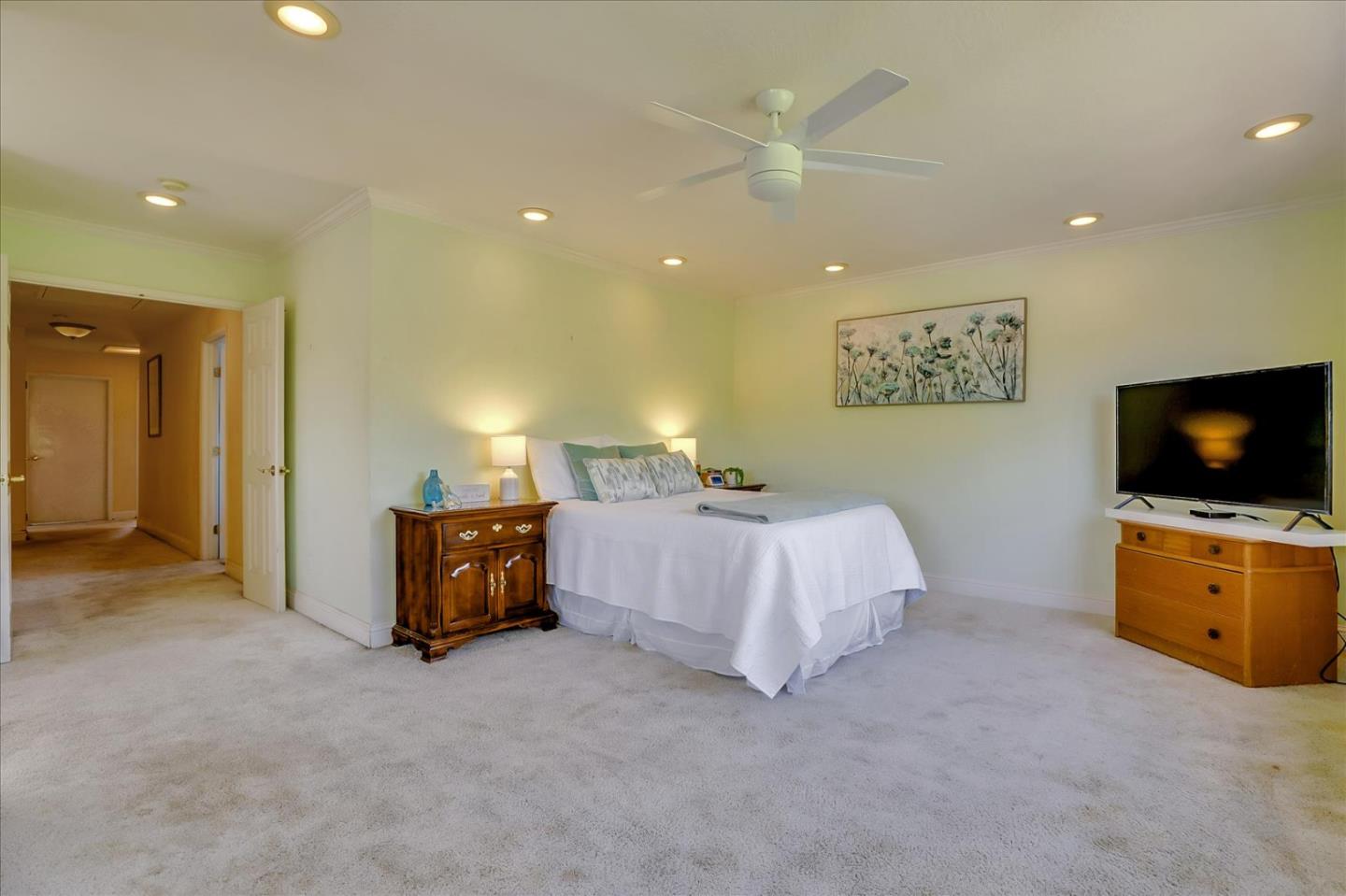 7166 Brooktree Way San Jose, CA 95120 - Photo 23 of 48 a spacious bedroom with a bed and a television in it