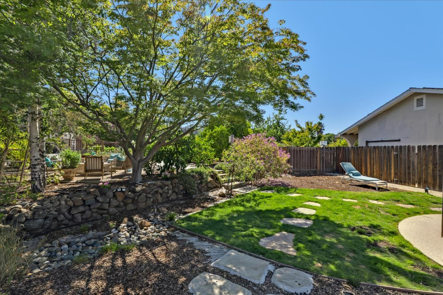 7166 Brooktree Way San Jose, CA 95120 - Photo 38 of 48 a backyard of a house with table and chairs plants and large tree