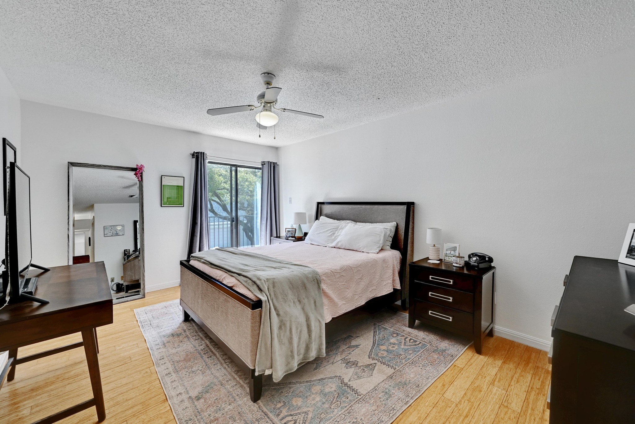 7635 Guadalupe Street, Unit 1002 Austin, TX 78752 - Photo 15 of 27 a bedroom with a bed dresser and a large mirror