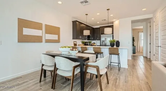 a kitchen with a dining table chairs stainless steel appliances and cabinets