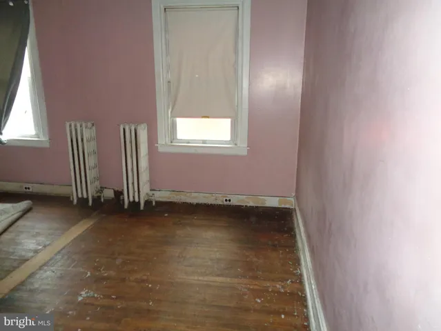 an empty room with a window and a ceiling fan