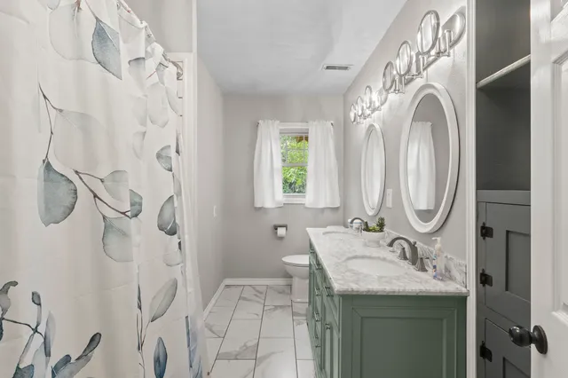 a bathroom with a granite countertop sink a mirror and a shower