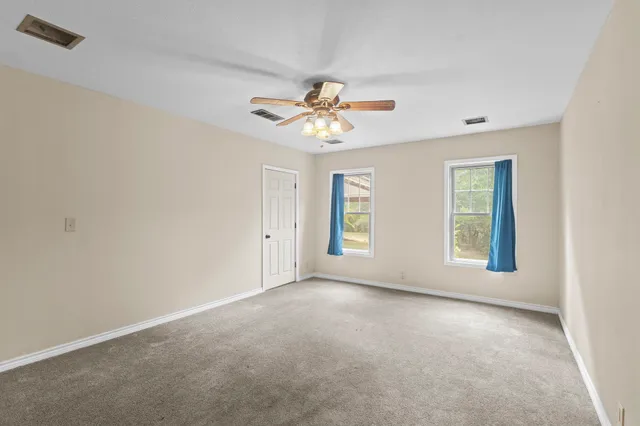 a view of a room with window and a chandelier fan