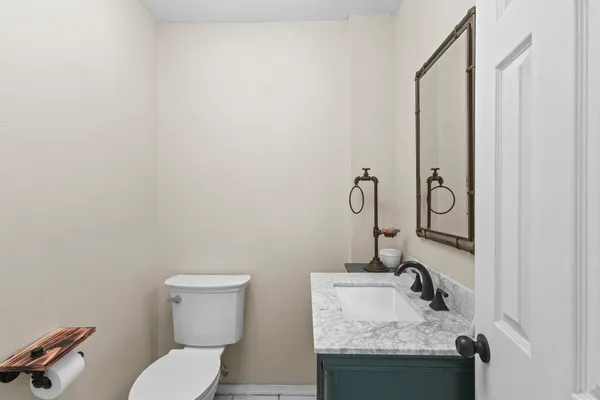 a bathroom with a granite countertop sink and a toilet