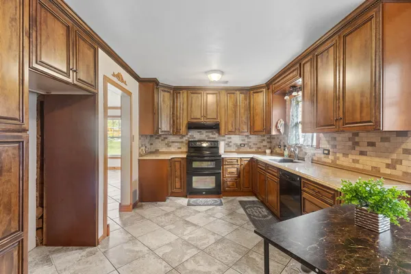 a kitchen with granite countertop stainless steel appliances cabinets a sink and a window