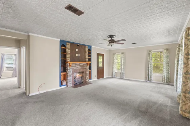 a view of a livingroom with a ceiling fan and windows