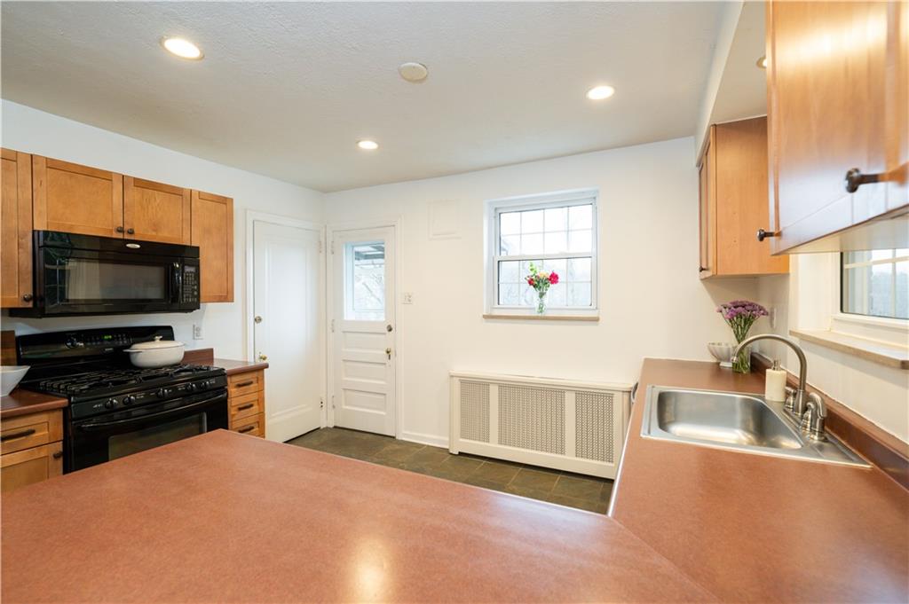 111 Sycamore Drive Pittsburgh, PA 15237 - Photo 12 of 24 a kitchen with granite countertop a stove a sink and a microwave
