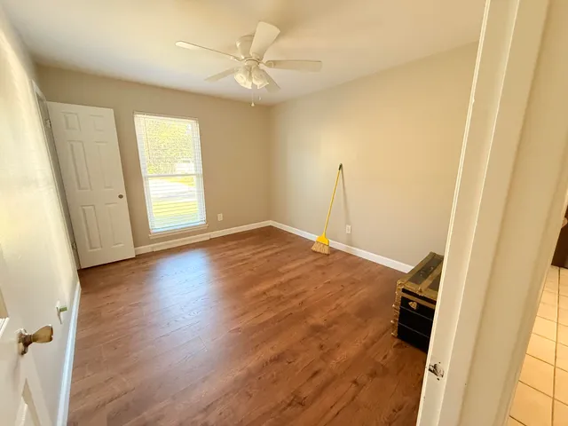 a view of a room with wooden floor and window