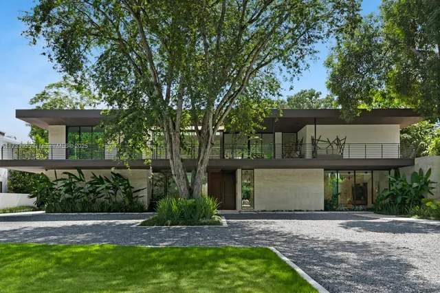 a front view of a house with a yard and potted plants