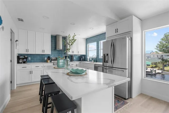 a kitchen with white cabinets and stainless steel appliances