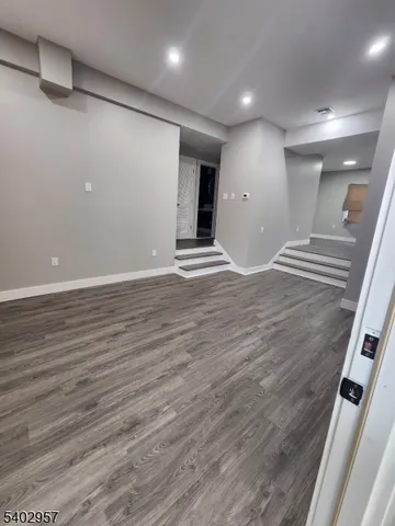 an empty room with wooden floor and natural light