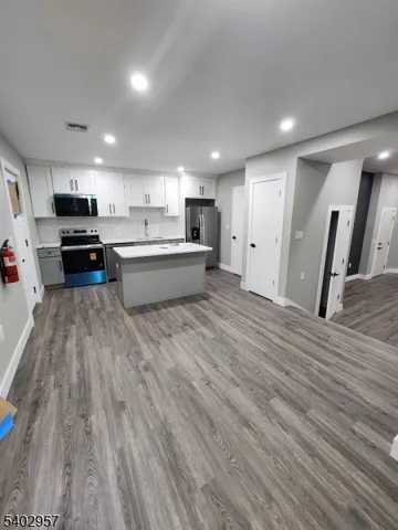 a large kitchen with stainless steel appliances wooden floors and wooden cabinets