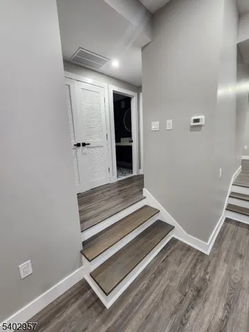 a view of a room with wooden floor and white walls