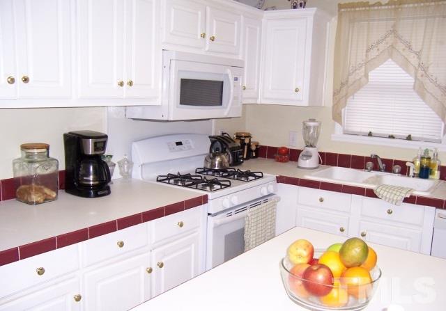 3370 Green Road Spring Hope, NC 27882 - Photo 8 of 25 a kitchen with a sink a stove and white cabinets