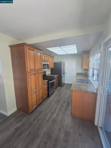 a kitchen with stainless steel appliances granite countertop a refrigerator and a stove top oven