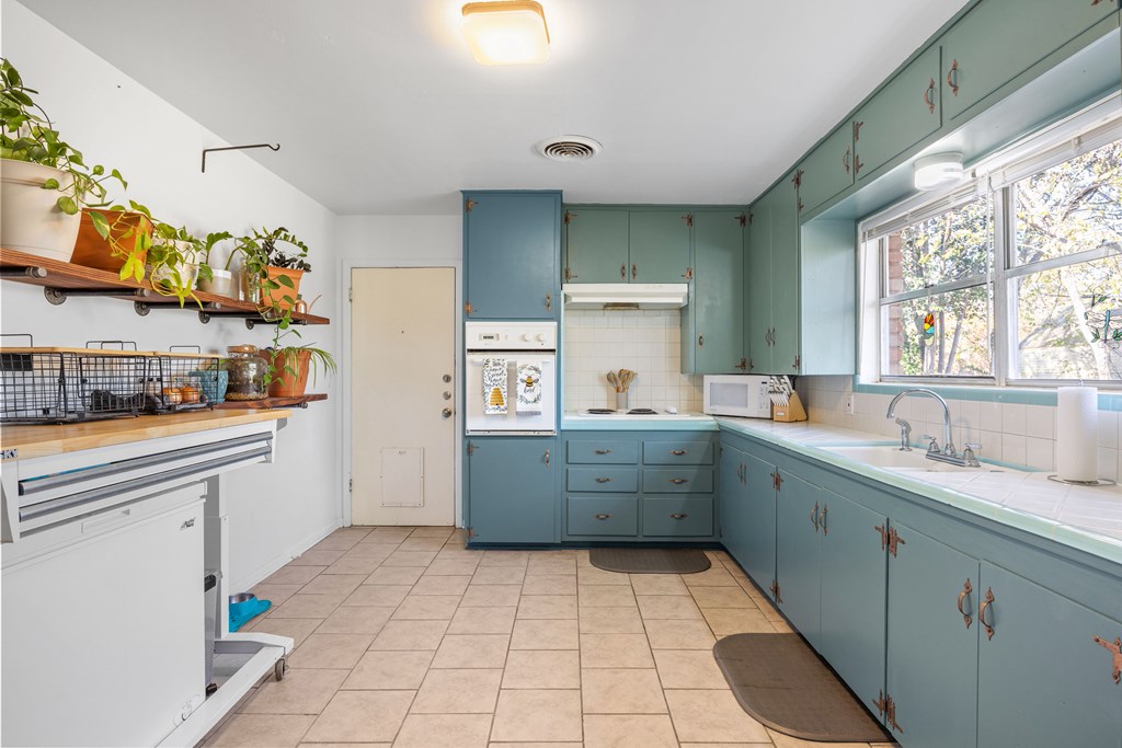 608 Rees Street Kerrville, TX 78028 - Photo 6 of 17 a kitchen with a sink window and cabinets