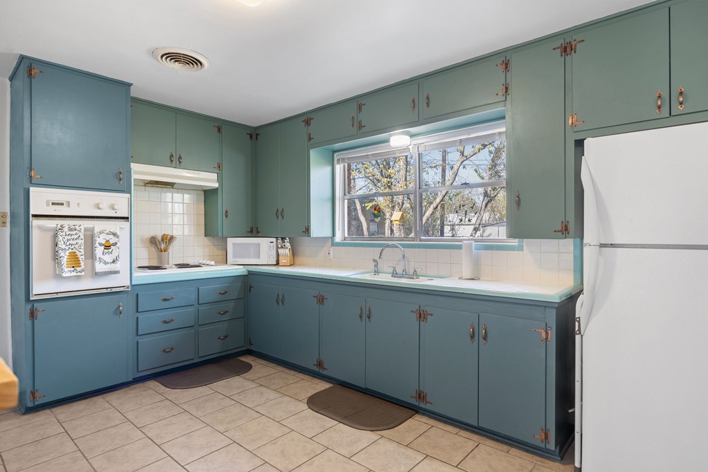 608 Rees Street Kerrville, TX 78028 - Photo 7 of 17 a kitchen with a sink cabinets and wooden floor