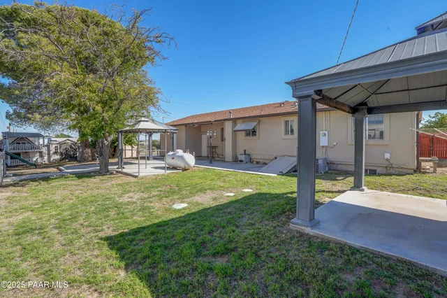 a view of a house with backyard and porch