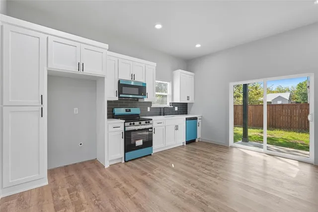 a kitchen with stainless steel appliances granite countertop a refrigerator and a stove