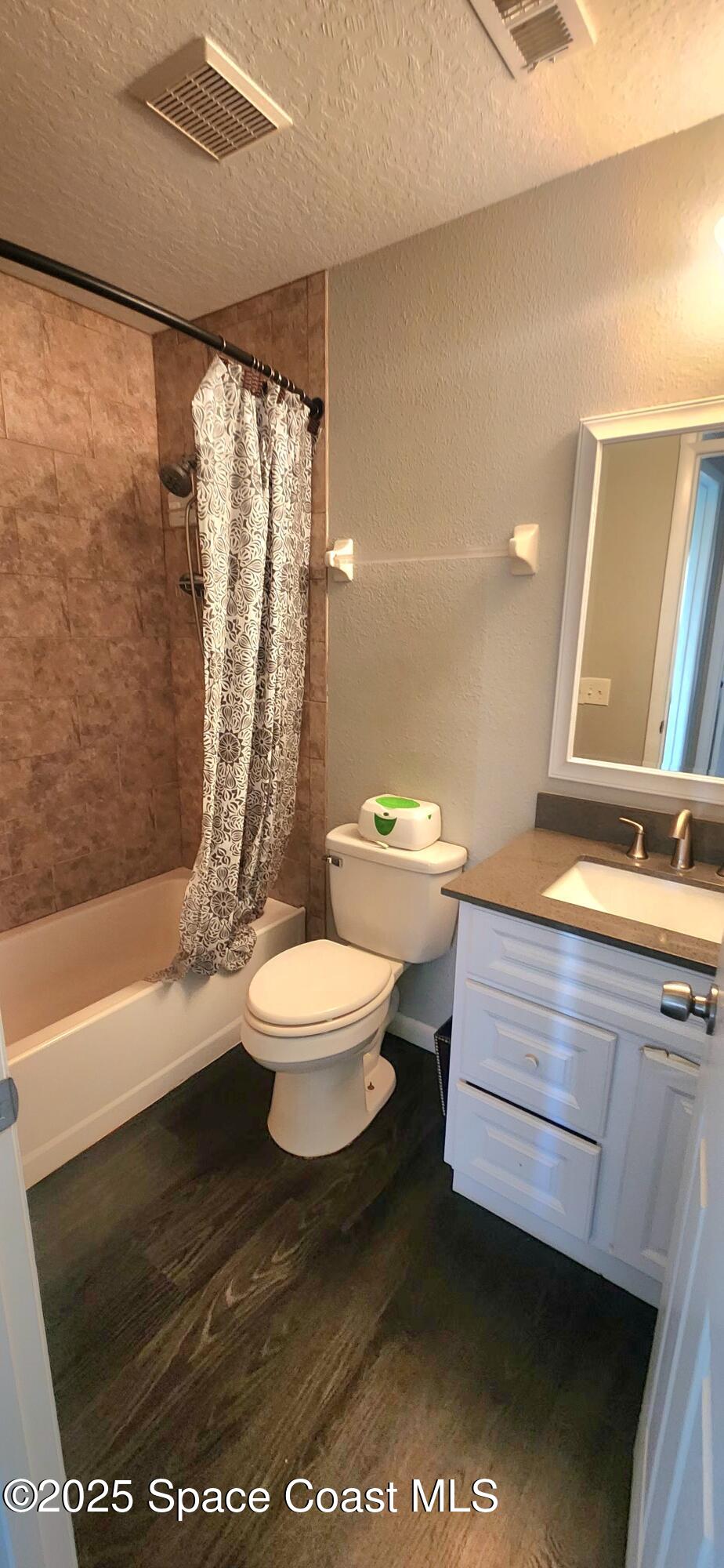 2014 Manor Drive Northeast Palm Bay, FL 32905 - Photo 23 of 24 a bathroom with a sink a toilet a mirror and shower