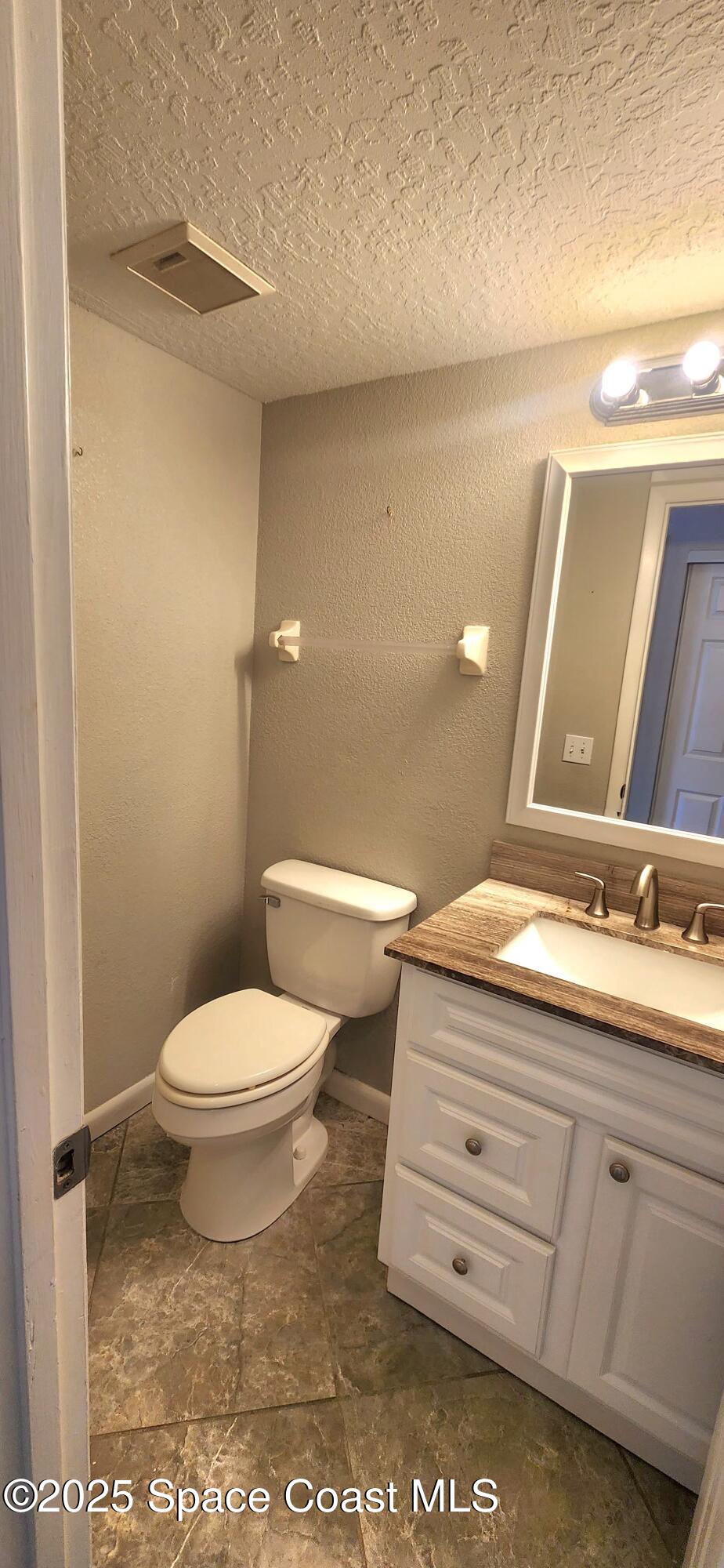 2014 Manor Drive Northeast Palm Bay, FL 32905 - Photo 8 of 24 a bathroom with a toilet a sink and mirror