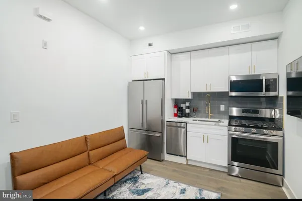 a kitchen with stainless steel appliances a stove a microwave and a refrigerator