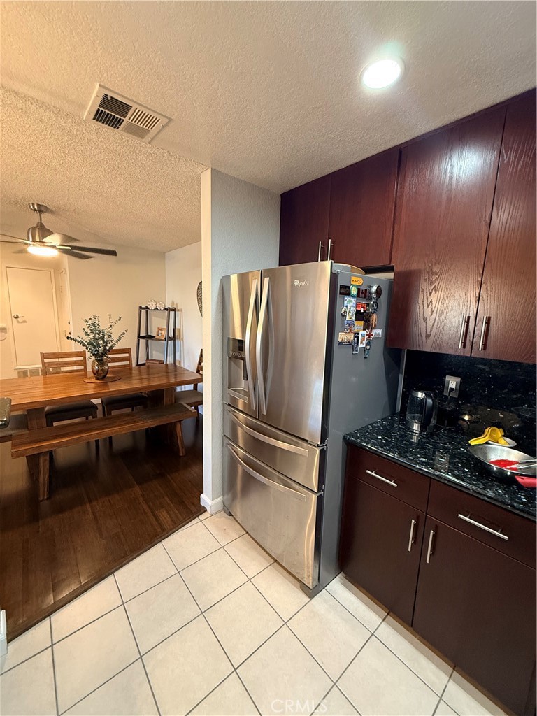 14630 Dickens Street, Unit 307 Sherman Oaks, CA 91403 - Photo 14 of 41 a kitchen with granite countertop a refrigerator and a stove top oven