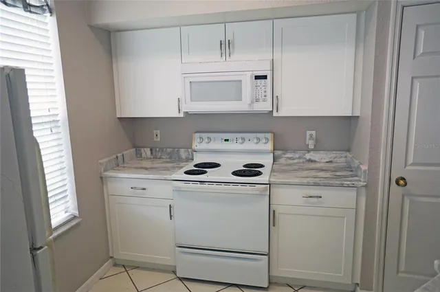 a kitchen with cabinets appliances a sink and a window