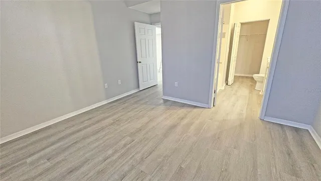 an empty room with wooden floor and door