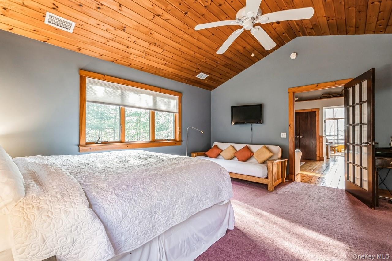 292 Little Fresh Pond Road Southampton, NY 11968 - Photo 25 of 46 a bedroom with a large bed and a chandelier