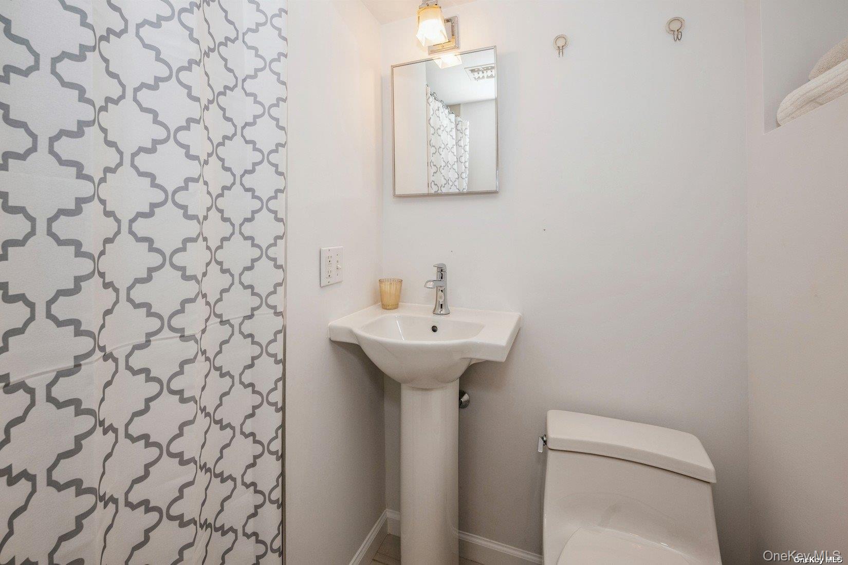 292 Little Fresh Pond Road Southampton, NY 11968 - Photo 34 of 46 a bathroom with a sink a toilet and mirror