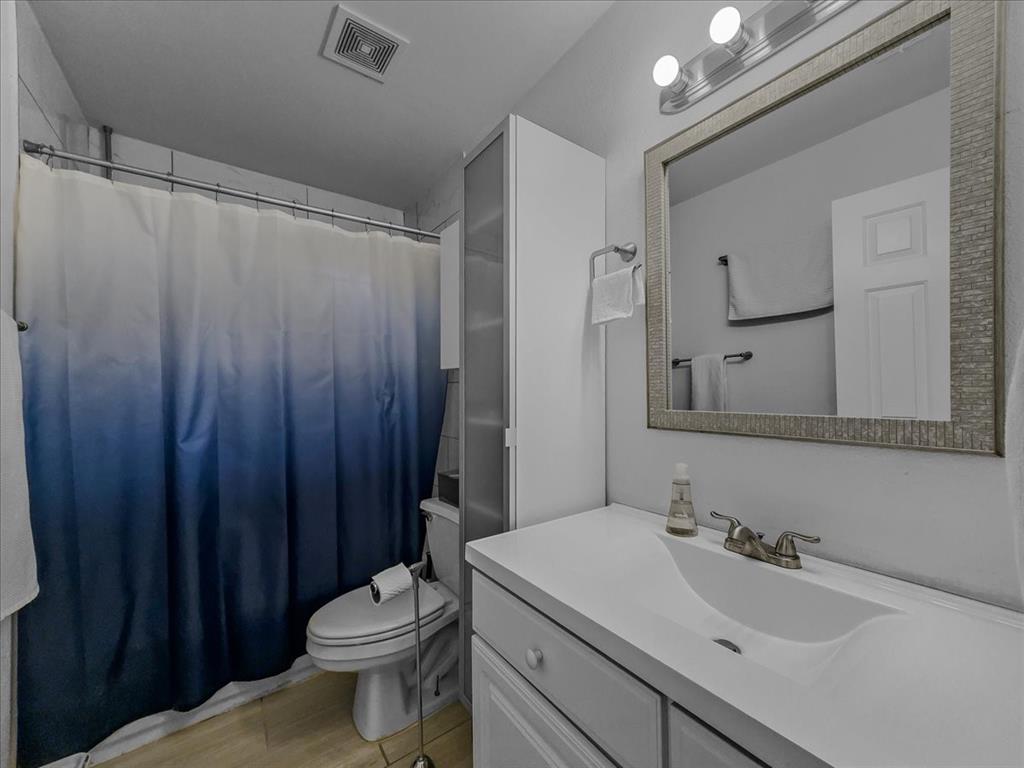 6206 Hidden Springs Lane Garland, TX 75044 - Photo 19 of 24 Full bath with vanity, toilet, a shower with curtain, and wood finished floors
