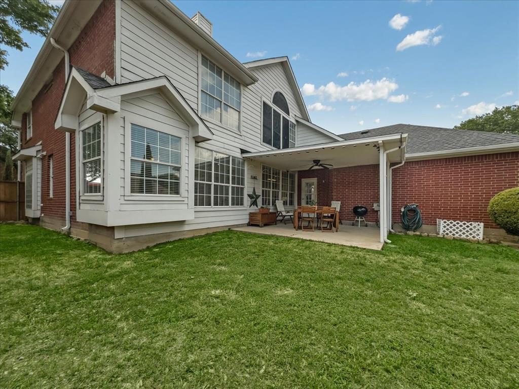 6206 Hidden Springs Lane Garland, TX 75044 - Photo 24 of 24 Rear view of house with a ceiling fan, brick siding, a patio area, a lawn.
