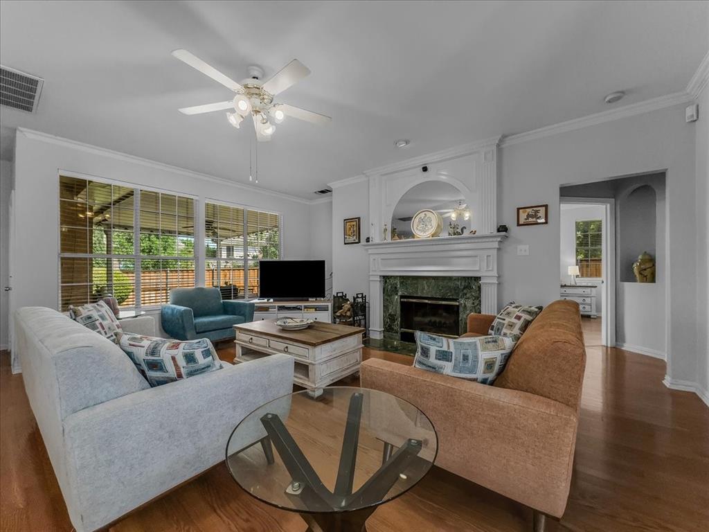 6206 Hidden Springs Lane Garland, TX 75044 - Photo 4 of 24 Living room with ornamental molding, a ceiling fan, wood finished floors, a high end fireplace, and baseboards