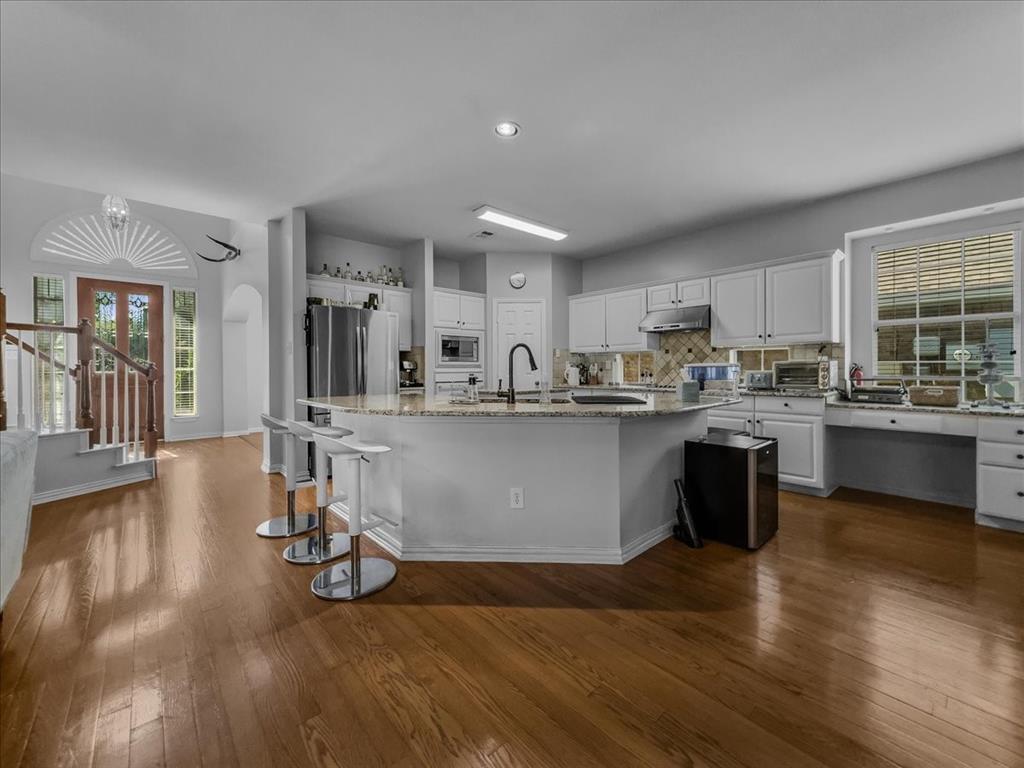 6206 Hidden Springs Lane Garland, TX 75044 - Photo 6 of 24 Kitchen with dark wood finished floors, an island with sink, white cabinetry, a sink, and recessed lighting