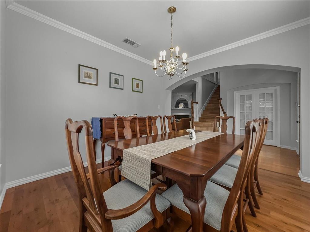 6206 Hidden Springs Lane Garland, TX 75044 - Photo 8 of 24 Dining room featuring arched walkways, stairway, baseboards, ornamental molding, and a chandelier