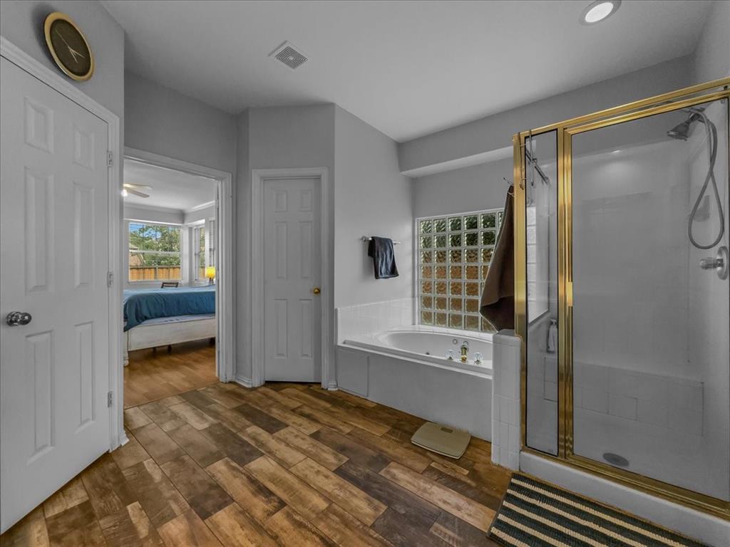 6206 Hidden Springs Lane Garland, TX 75044 - Photo 10 of 24 Bathroom featuring wood finished floors, a garden tub, a stall shower, recessed lighting, and ensuite bathroom