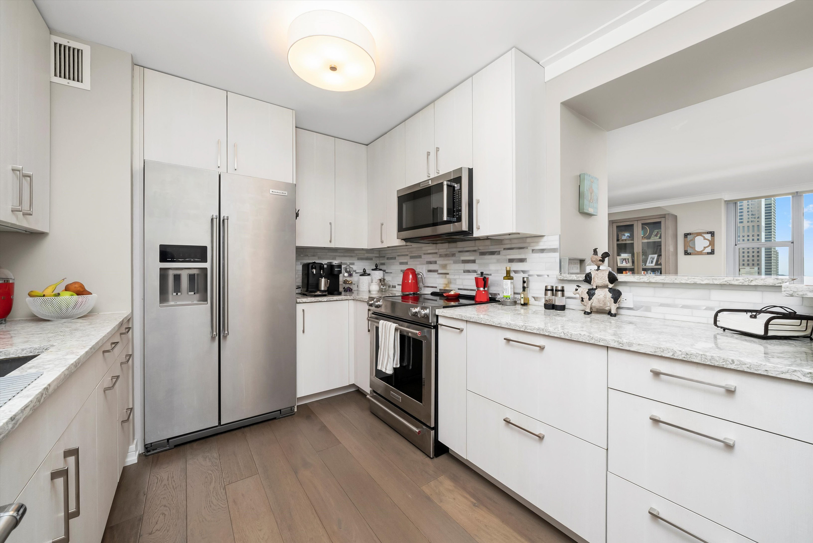 777 North Michigan Avenue, Unit 1601 Chicago, IL 60611 - Photo 3 of 44 a kitchen with white cabinets and stainless steel appliances