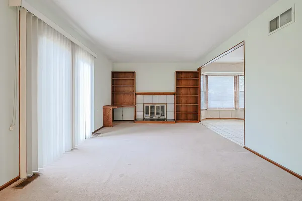 a view of empty room with windows and cabinet