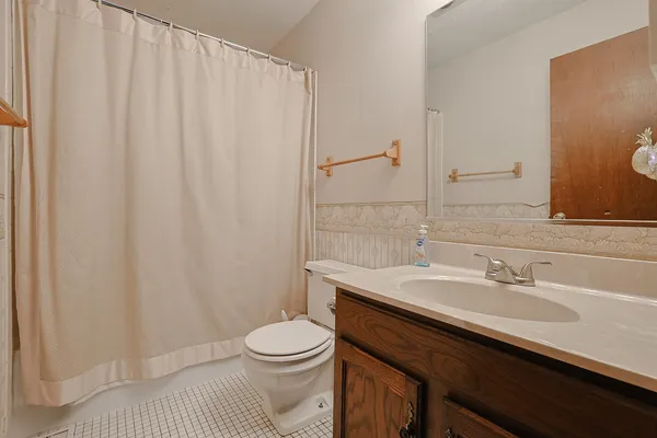 a bathroom with a sink a toilet and shower curtain