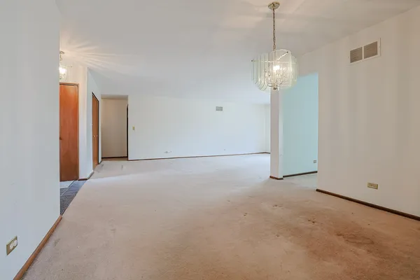 a view of an empty room with a chandelier