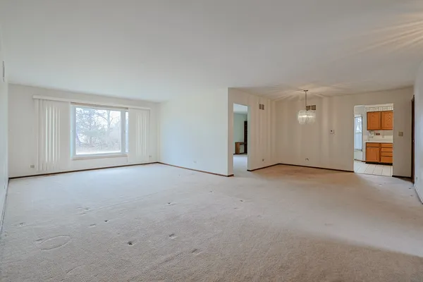 a view of an empty room with a window and closet area