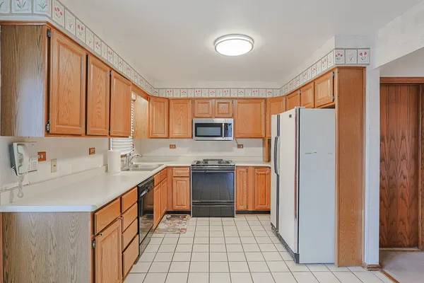 a kitchen with stainless steel appliances granite countertop a refrigerator stove top oven a sink and dishwasher