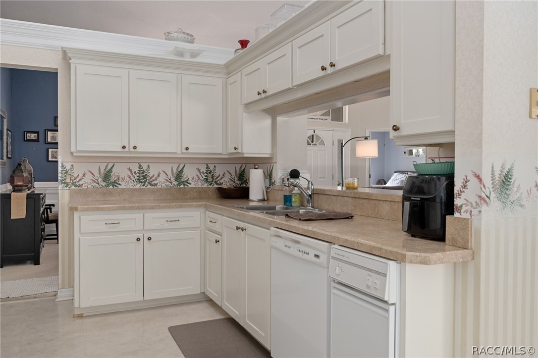 2460 West Pine Ridge Boulevard Beverly Hills, FL 34465 - Photo 13 of 47 a kitchen with granite countertop white cabinets and white appliances